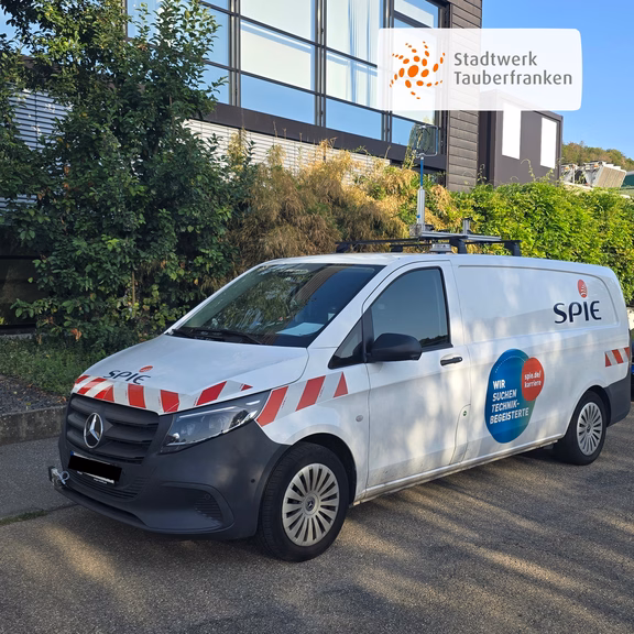 Weißes Messfahrzeug der Firma SPIE mit Sensorik auf dem Fahrzeugdach. Das Fahrzeug wird im Auftrag des Stadtwerks Tauberfranken zur Kontrolle des Gasrohrnetzes und zur Erkennung möglicher Undichtigkeiten eingesetzt.