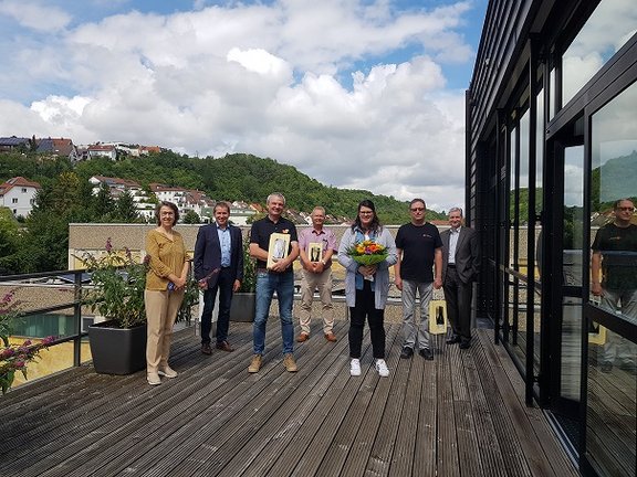 Geschäftsführung steht mit langjährigen Mitarbeitern auf der Terasse