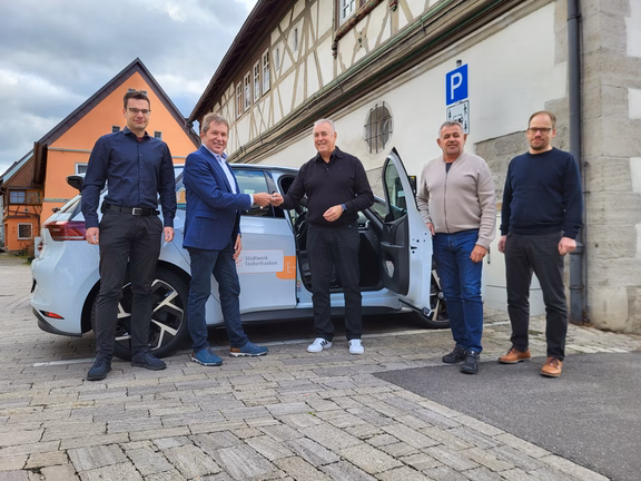 Carsharing Grünsfeld Fünf Personen bei der Fahrzeugübergabe für Carsharing in Grünsfeld mit einem Elektroauto von Stadtwerk Tauberfranken