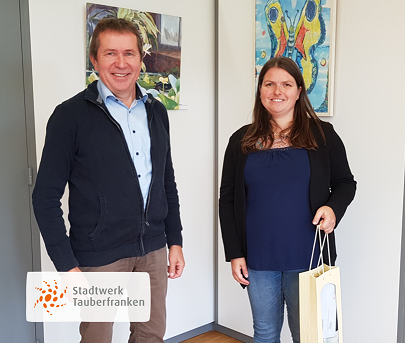 Mitarbeiterin erhält Weingebinde durch Geschäftsführer