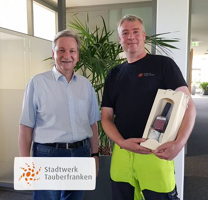 Mitarbeiter erhält ein Weingebinde vom Geschäftsführer