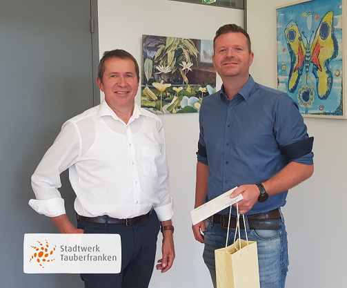 Ehrung Megele Mitarbeiter erhält Weingebinde vom Geschäftsführer