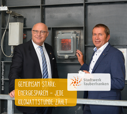 Energiesparen Geschäftsführer und OB stehen vor der Brennkammer im Naturwärmekraftwerk